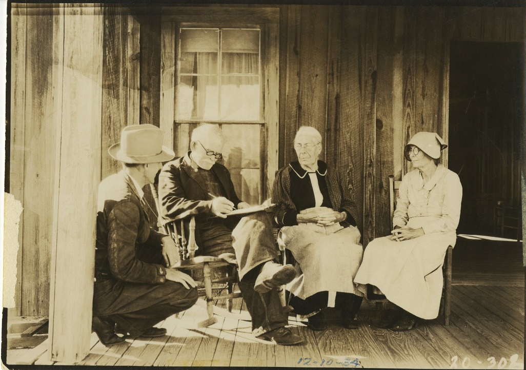 4 people on the porch of old home